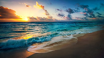 Vibrant Sunset Over Turquoise Ocean Waves Crashing on Sandy Beach
