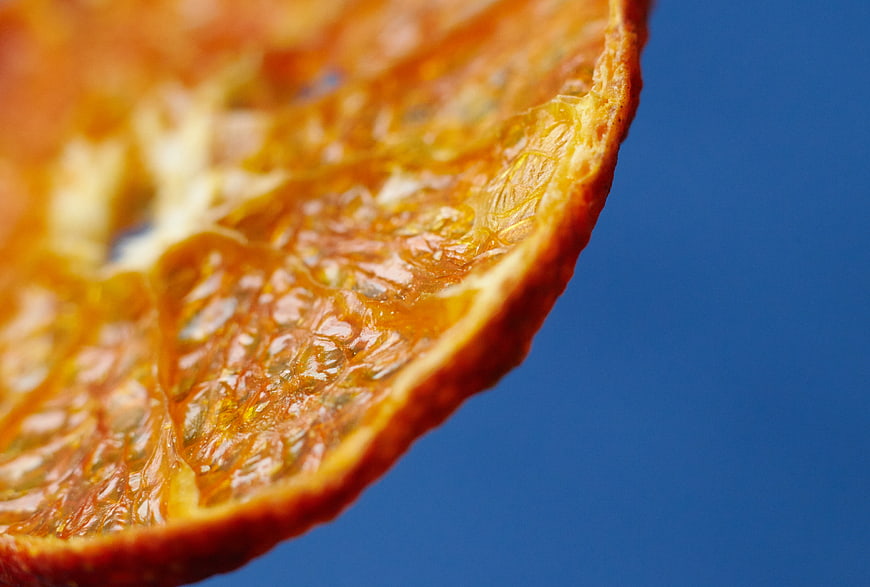 Macro shot of dried orange slice on blue background