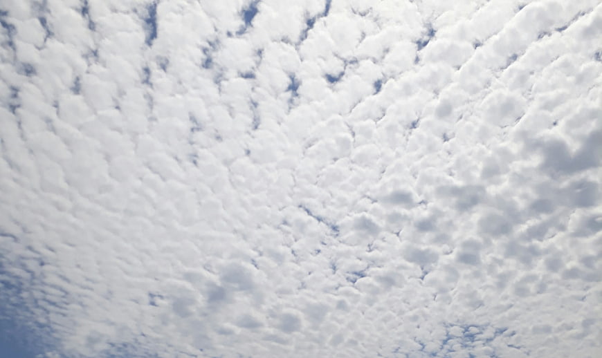 Texture of white altocumulus clouds against blue sky