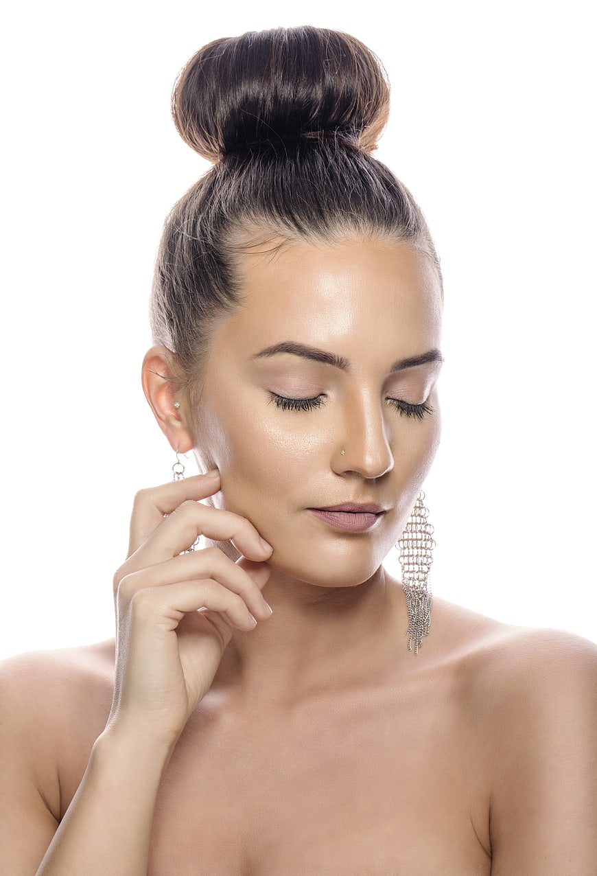 Beauty Portrait of Woman With High Bun And Silver Earrings