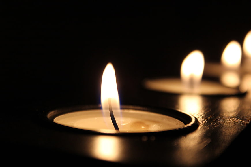 Close-up of burning tea candles in the dark