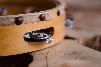Close-up of wooden tambourine with metal jingles on rustic wood