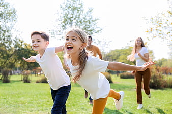 Happy family running and playing together in a sunny park