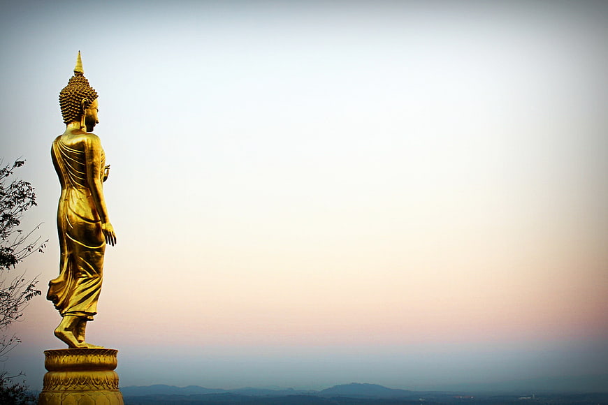 Golden Buddha Statue Silhouette Against Sunset Sky