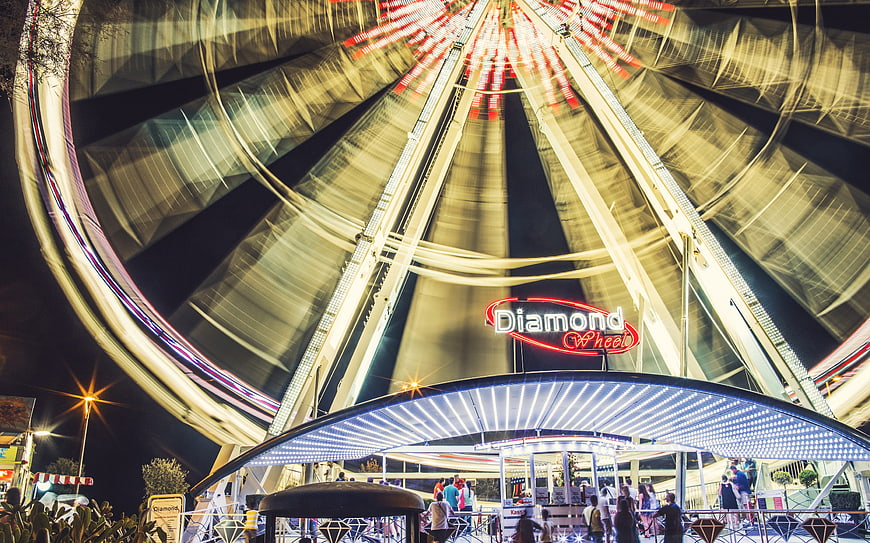 Long Exposure Night Shot of Spinning Ferris Wheel with Light Trails