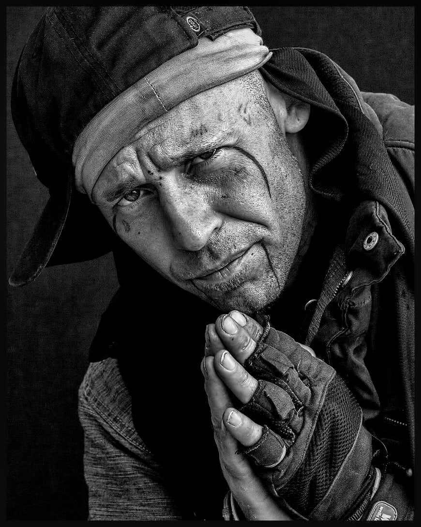 Black and white portrait of a distressed man with dirty face