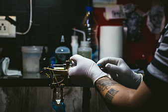 Tattoo Artist Hands Preparing Machine in Studio