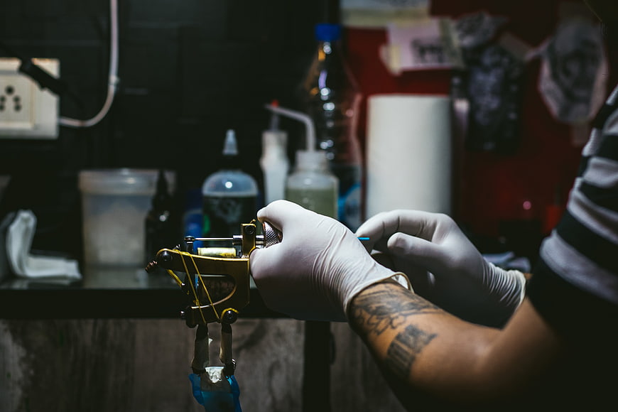 Tattoo Artist Hands Preparing Machine in Studio