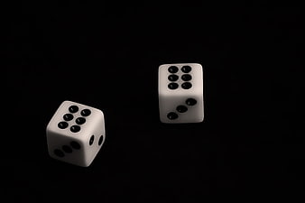 Two white dice showing sixes on black background