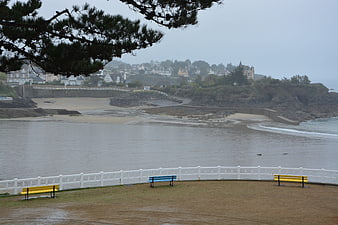 Coastal landscape with colorful benches and overcast sea view