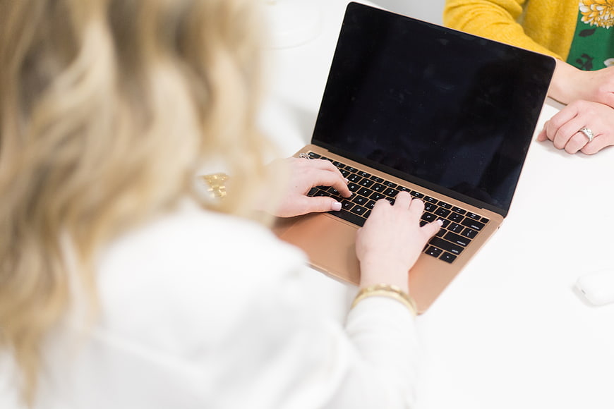 Woman Typing on Gold Laptop in Office