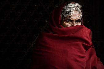 Senior Woman Wrapped in Red Shawl with Intense Gaze