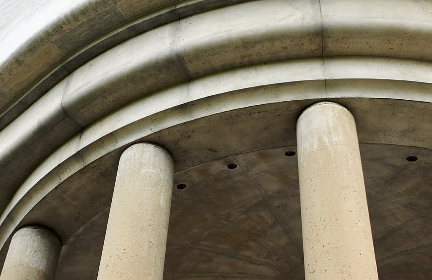 Low angle view of weathered concrete architectural columns and arches