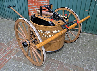 Vintage wooden horse-drawn fire engine cart with large wheels