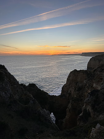 Sunset over Rugged Coastal Cliffs and Ocean Horizon