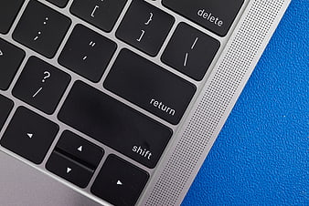 Close-up of laptop keyboard on blue textured background