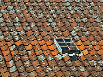 Weathered terracotta roof tiles with skylight window