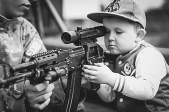 Young Boy Peering Through Rifle Scope