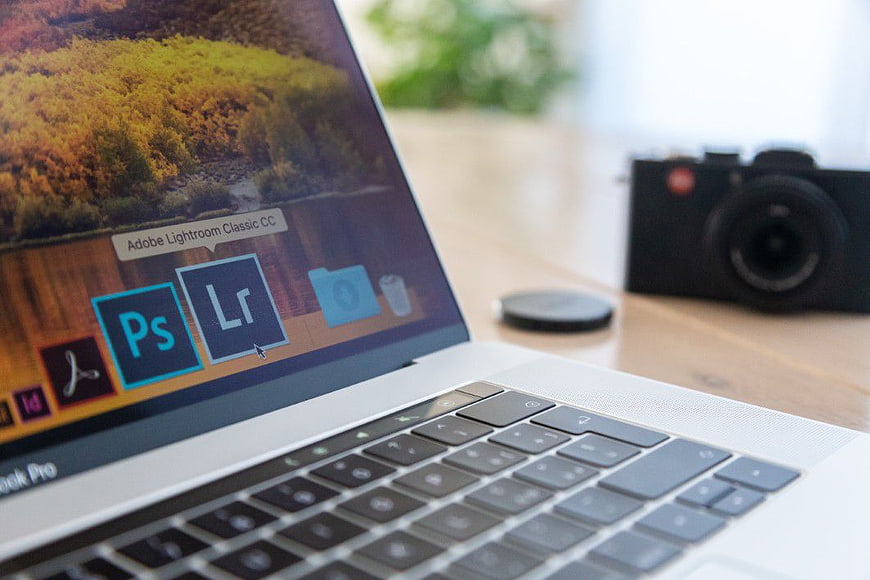 Laptop Screen Showing Adobe Lightroom and Photoshop with Camera
