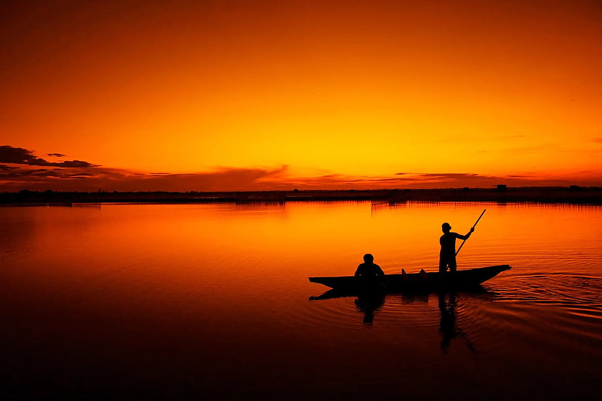 Silhouette of Two People in a Boat at Sunset