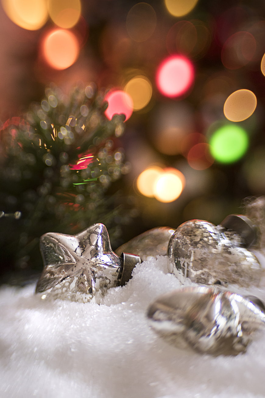 Silver Christmas Ornaments in Snow with Bokeh Lights