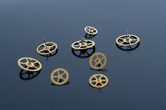 Gold watch gears on dark reflective surface