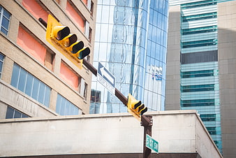 Yellow traffic lights and street sign in urban cityscape