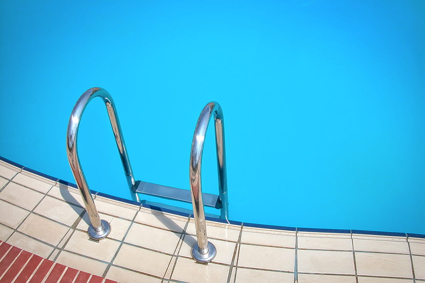 Chromium Pool Ladder Against Vibrant Blue Water