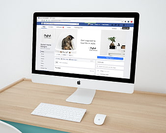 iMac displaying Facebook business page on wooden desk