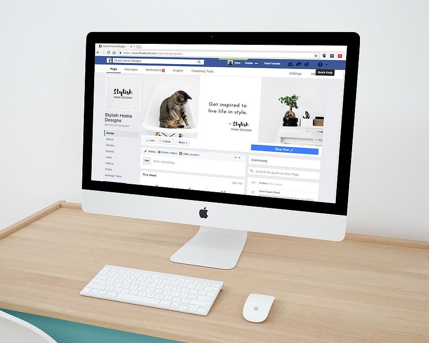 iMac displaying Facebook business page on wooden desk