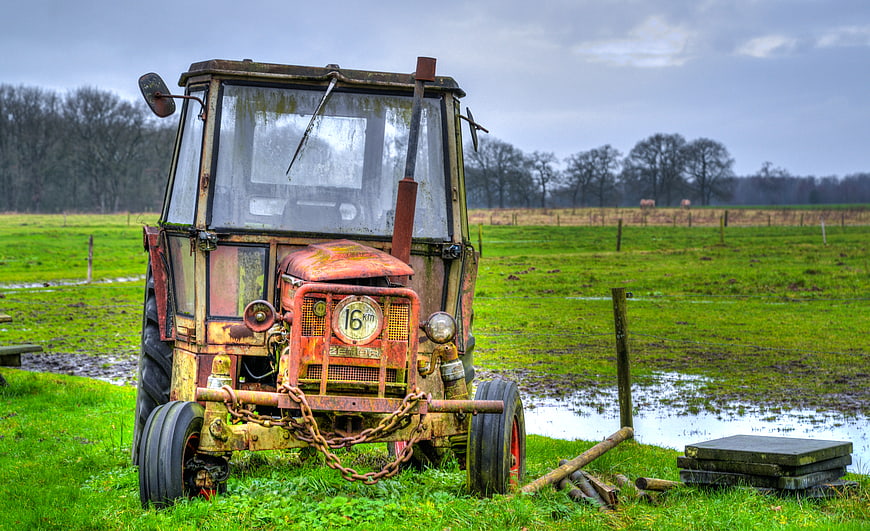 Rusty vintage tractor in green field