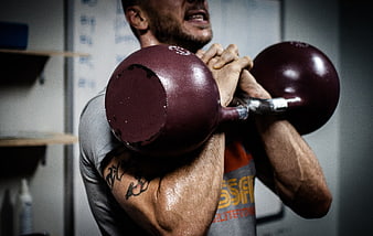 Man lifting heavy kettlebell during intense gym workout
