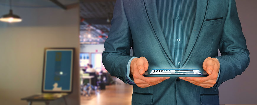 Businessman holding tablet with holographic interface in office