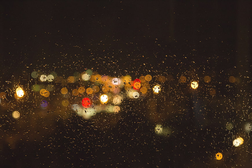 Abstract Night City Bokeh Through Rainy Window Glass