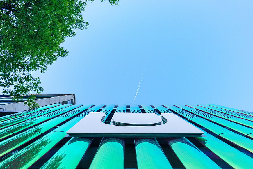Low angle view of modern green glass building facade