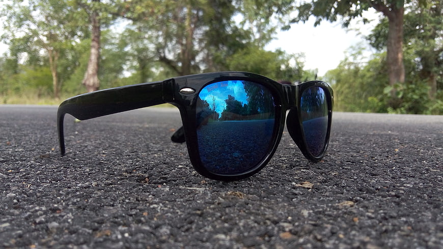 Black Sunglasses with Blue Lenses on Asphalt Road