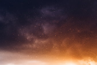 Starry night sky with orange and purple nebula clouds