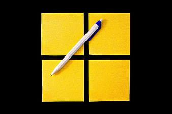 Four yellow sticky notes and a white pen on a black background