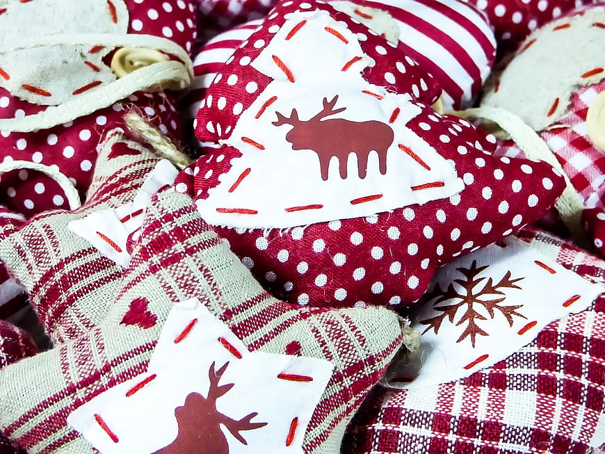 Close-up of handmade Christmas fabric ornaments with reindeer and snowflake patterns