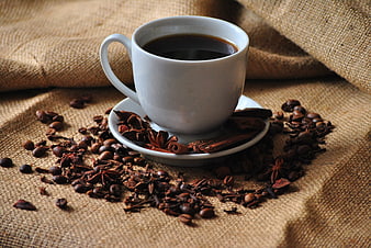 White Cup of Black Coffee with Spices on Burlap
