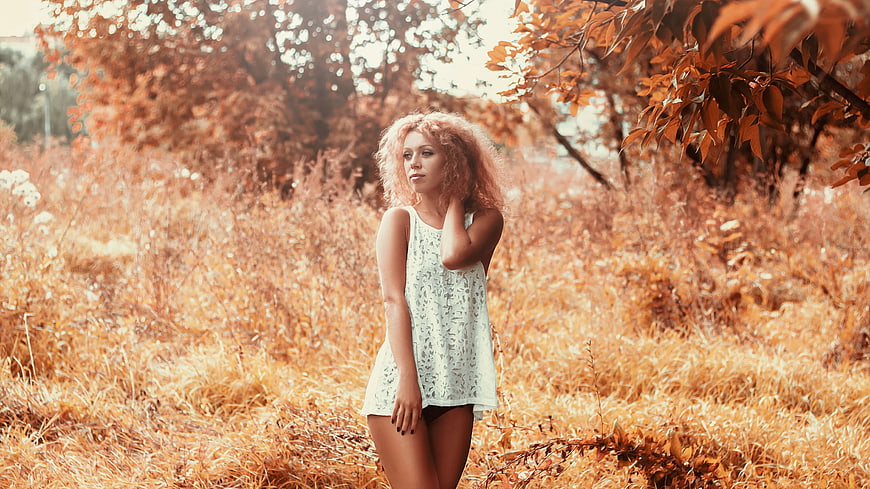 Woman with curly hair in autumn field