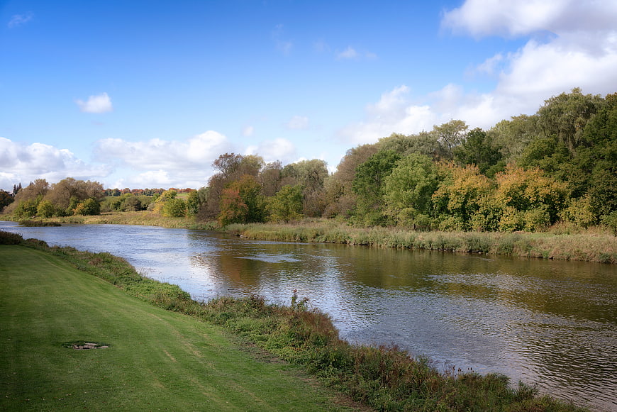 Serene River Landscape with Green Banks and Blue Sky
