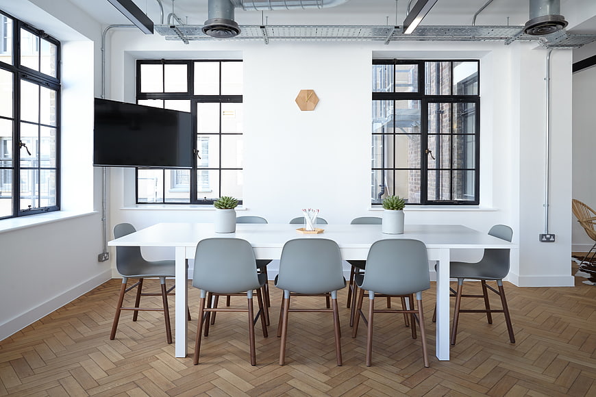 Modern minimalist office meeting room with white table and chairs