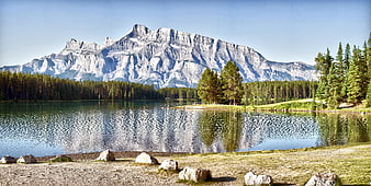 Scenic mountain lake landscape with forest and rocky shoreline