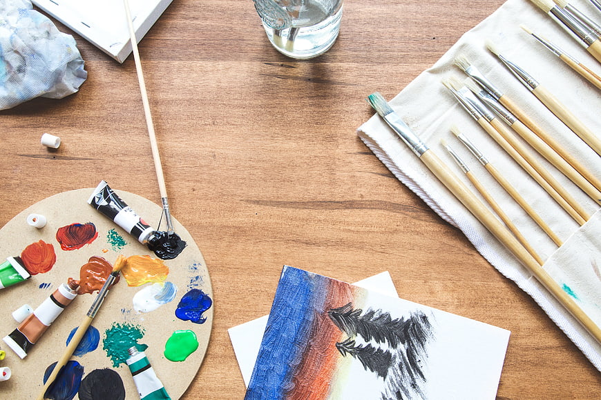 Flat Lay of Acrylic Paint Supplies on Wooden Desk