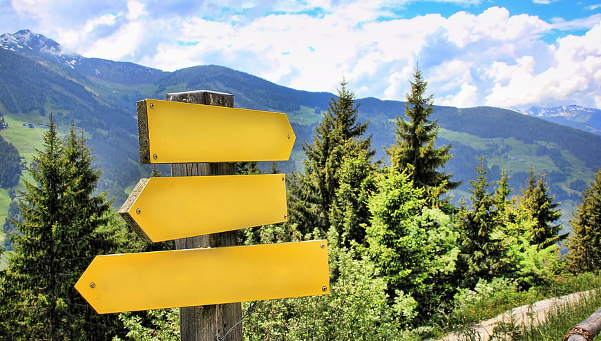 Yellow Wooden Signpost in Alpine Mountain Landscape