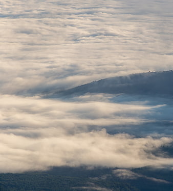 Mountain Peaks Rising Above Thick Sea of Clouds