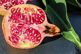 Fresh Pomegranate Half with Seeds on Dark Slate
