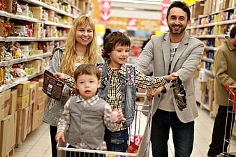 Happy family shopping for groceries with children in cart