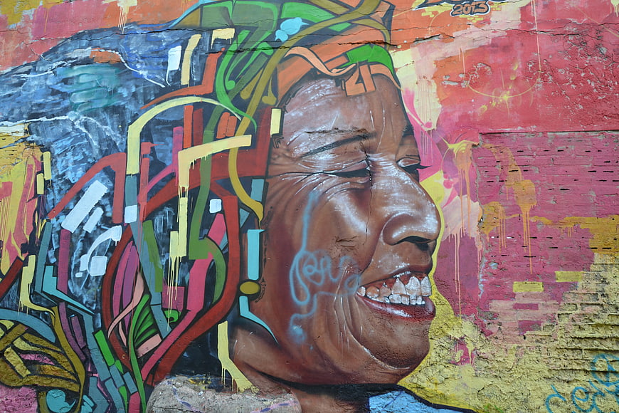 Vibrant Street Art Mural of Elderly Woman Profile on Weathered Brick Wall
